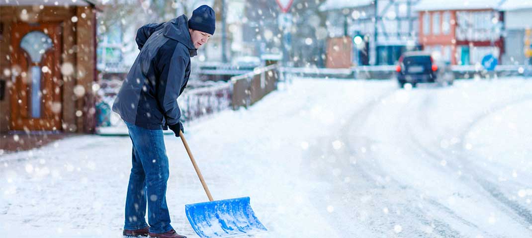 Mann räumt Schnee